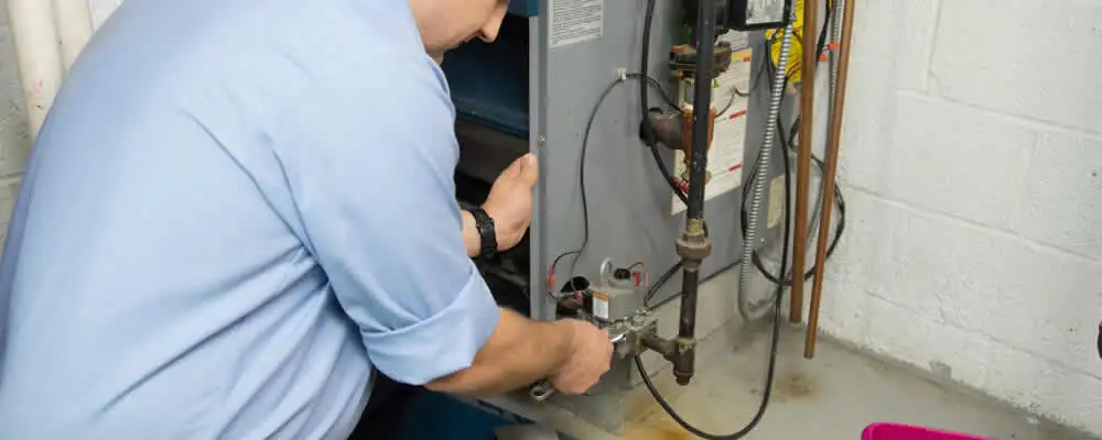 Furnace repair technician inspecting and servicing a home heating system in Loveland, CO