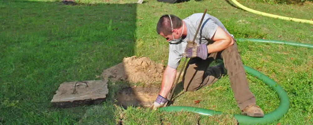 Septic pumping technician servicing a residential septic tank in Loveland, CO